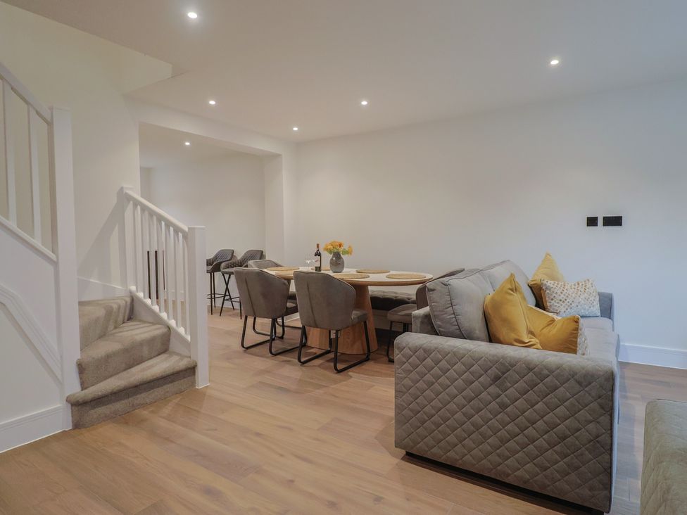 A living room with a staircase and dining area at Oak lodge in Westonzoyland nr. Bridgwater