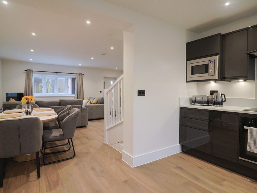 A dining room with a table and chairs and a kitchen area at Oak lodge Westonzoyland nr. Bridgwater
