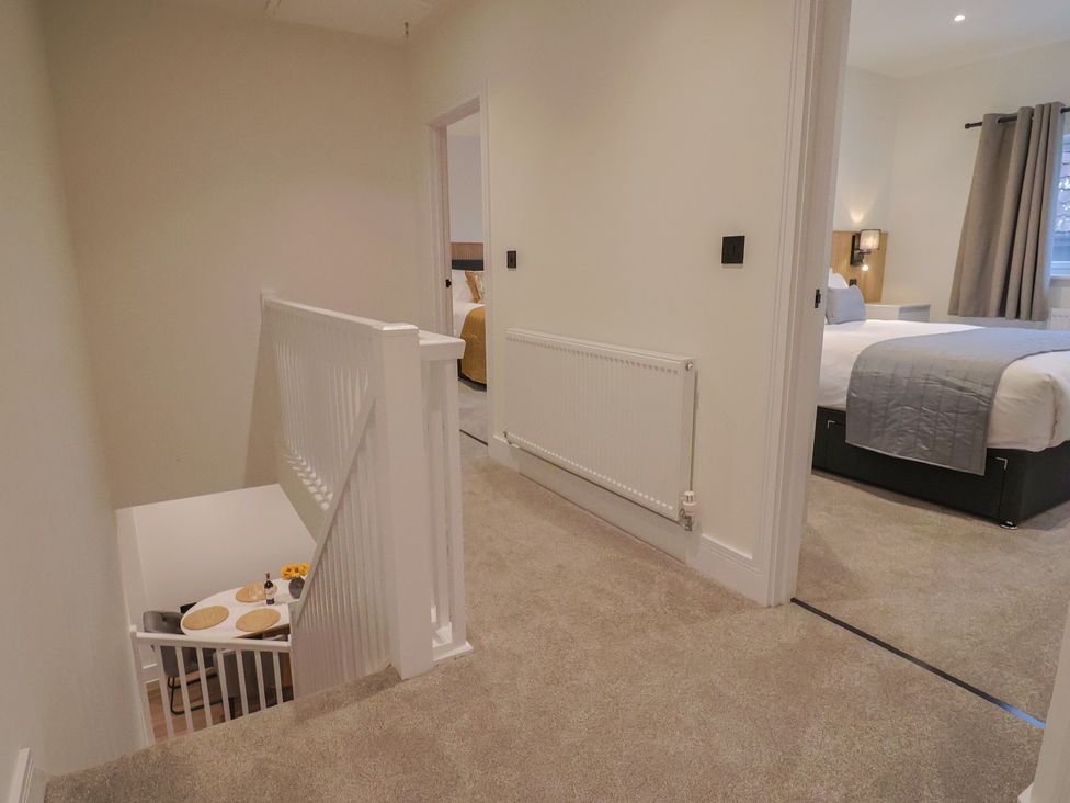 A hallway with a staircase and a dining table at Oak lodge Westonzoyland nr. Bridgwater