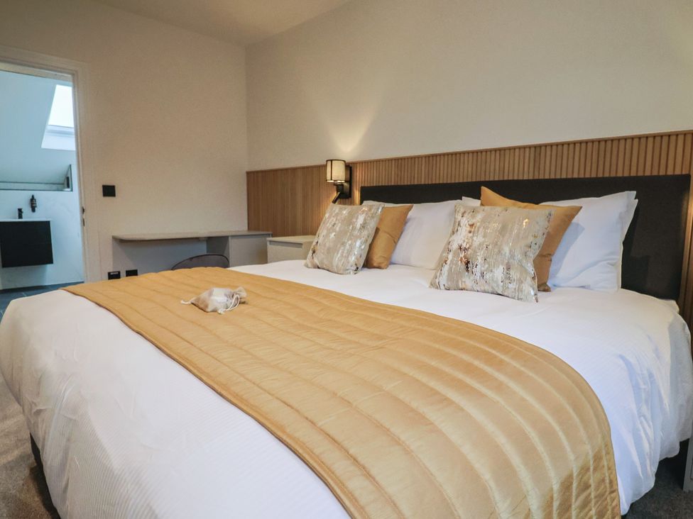 A bedroom with a large bed and a desk at Oak lodge in Westonzoyland nr. Bridgwater