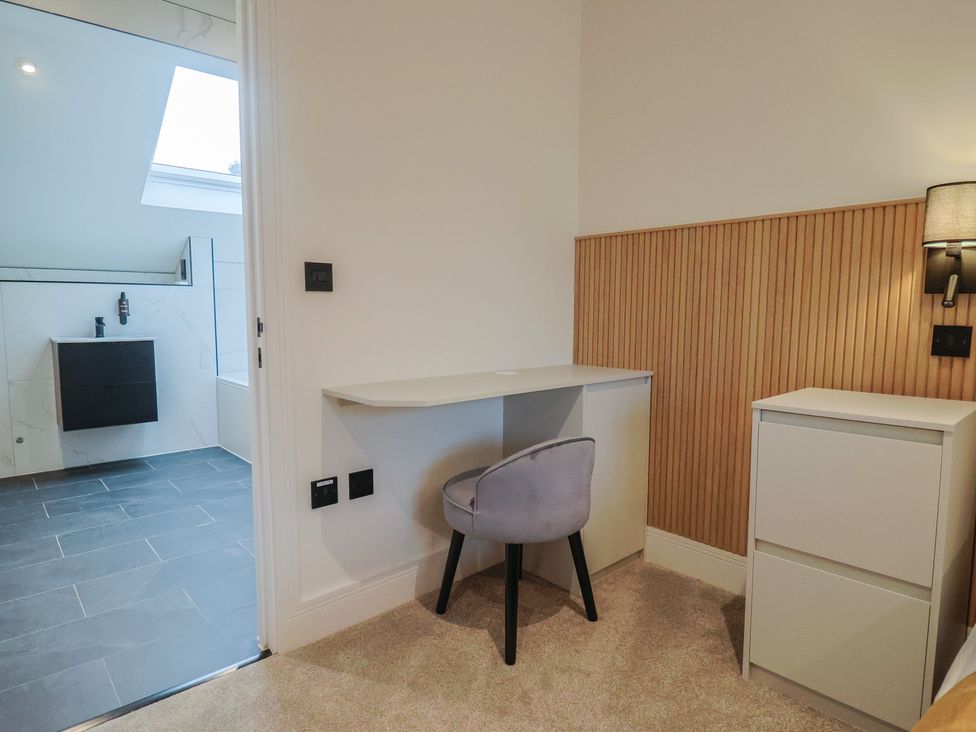 A bathroom with a sink and shower beside a study area at Oak lodge in Westonzoyland nr. Bridgwater