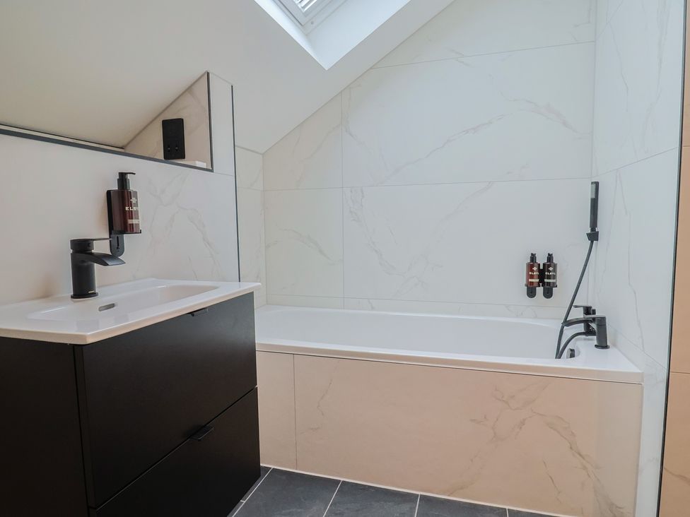 A bathroom with a bathtub and sink at Oak lodge in Westonzoyland nr. Bridgwater