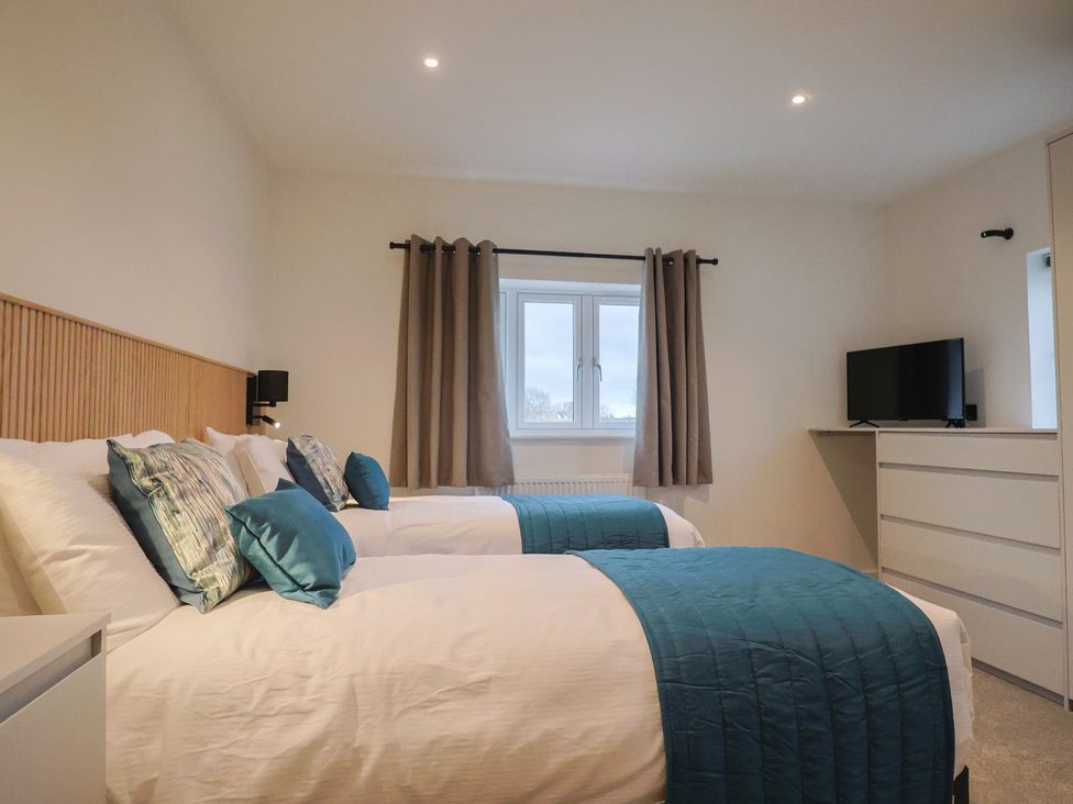 A bedroom with two beds and a television at Oak lodge Westonzoyland nr. Bridgwater