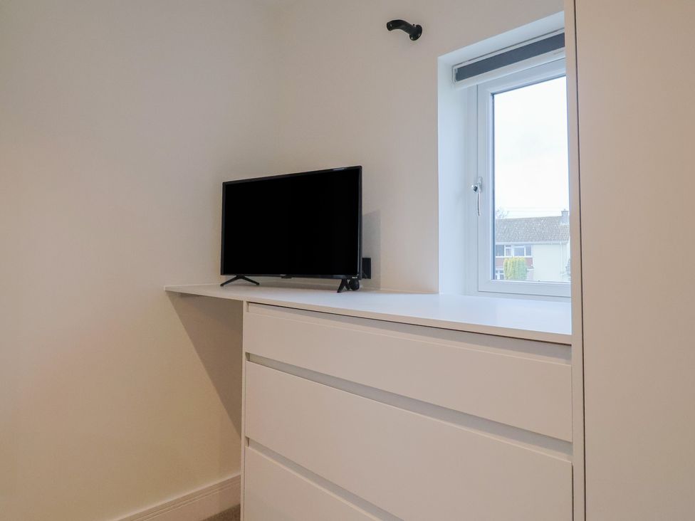 A bedroom with a television on a shelf and a window at Oak lodge Westonzoyland nr. Bridgwater