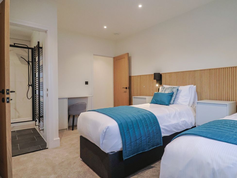 A bedroom with two beds and a shower at Oak lodge in Westonzoyland nr. Bridgwater