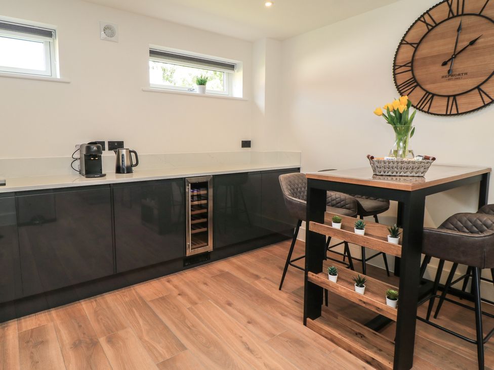 A kitchen with a counter, coffee maker, and dining table at Oak Lodge Westonzoyland nr. Bridgwater