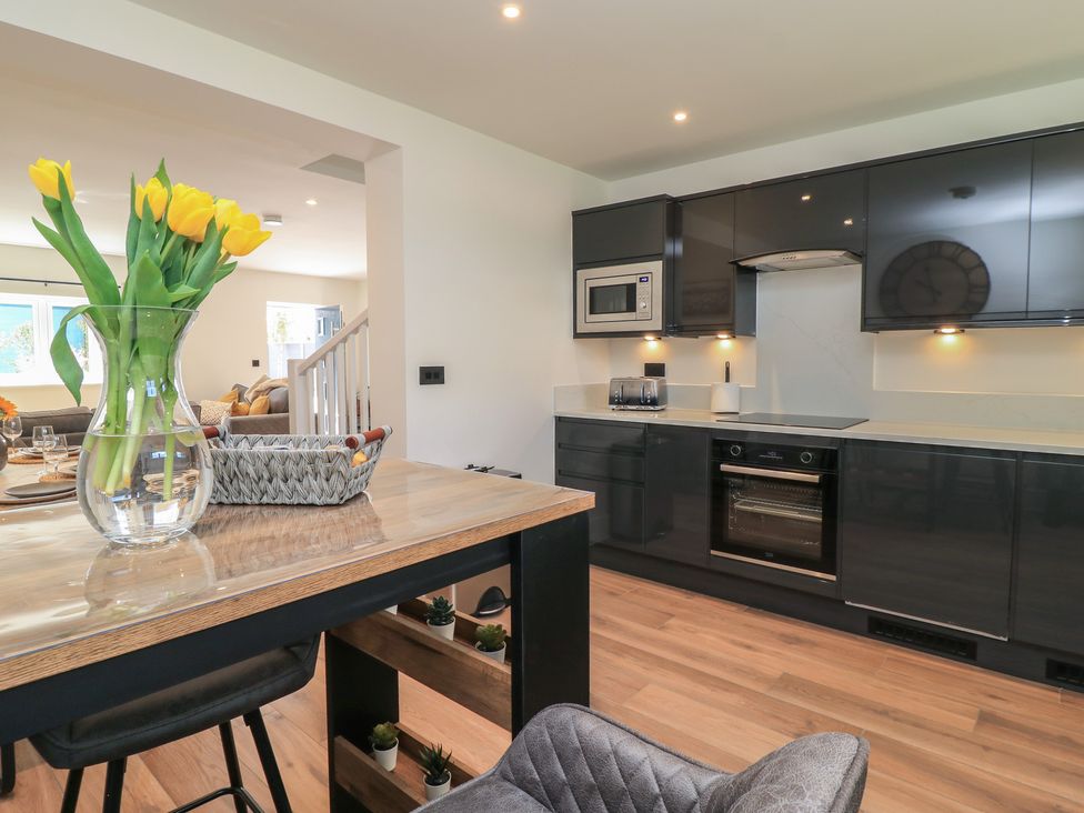 A kitchen with a vase of flowers and modern appliances at Oak Lodge Westonzoyland nr. Bridgwater