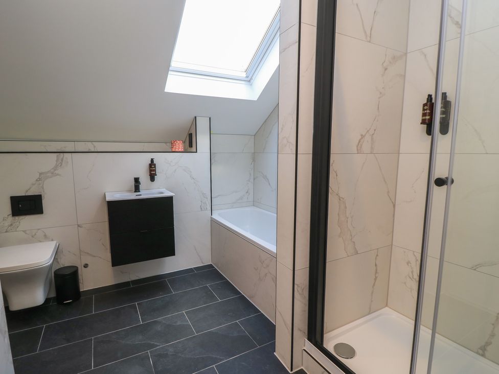 A bathroom with a bathtub and shower at Oak Lodge in Westonzoyland nr. Bridgwater
