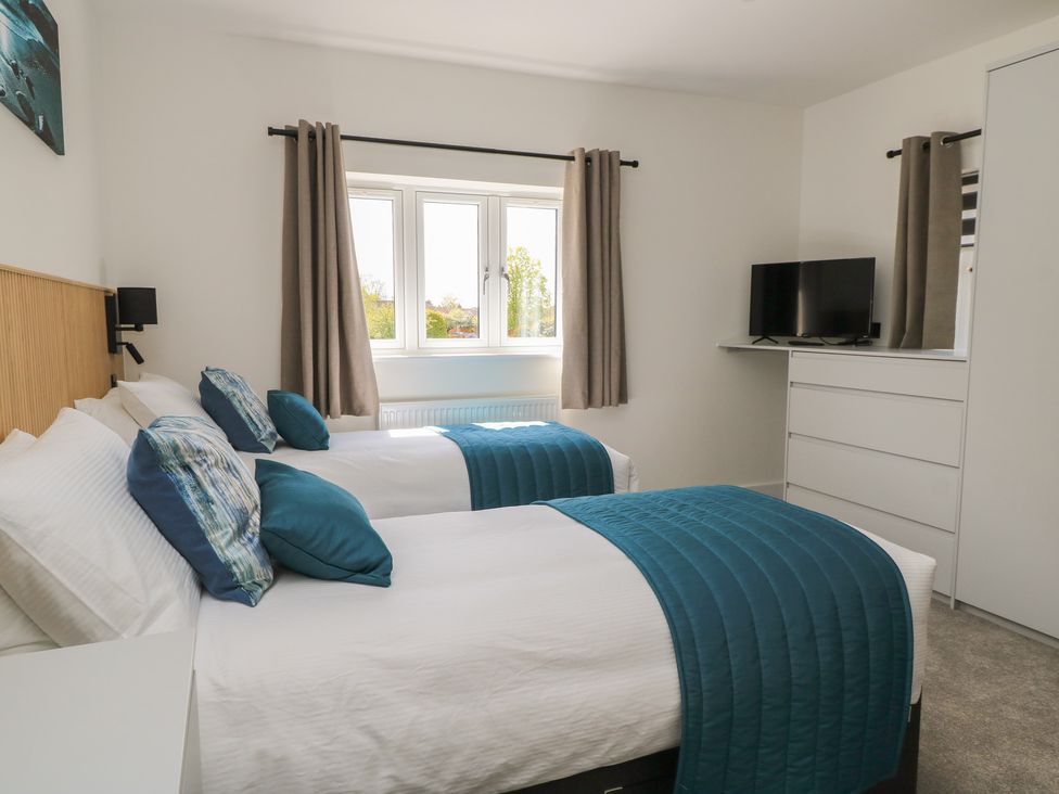 A bedroom with two beds and a television at Oak Lodge in Westonzoyland nr. Bridgwater