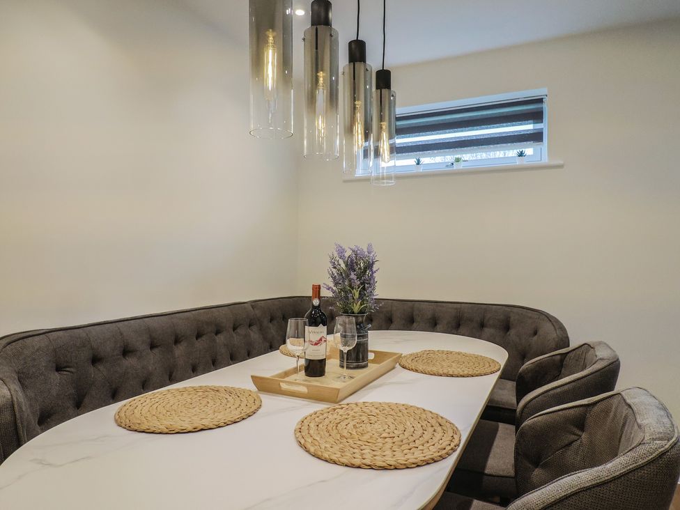 A dining room with a table and wine at Pine Lodge Westonzoyland nr. Bridgwater