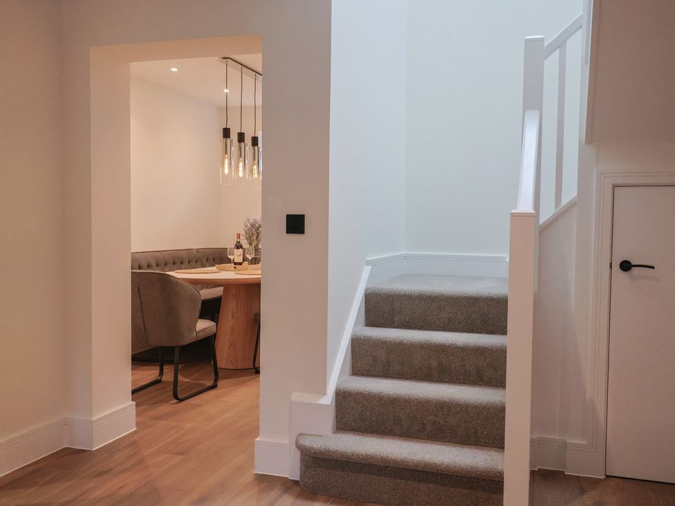 A staircase leading to an upper level with a view of the dining area at Pine Lodge Westonzoyland nr. Bridgwater