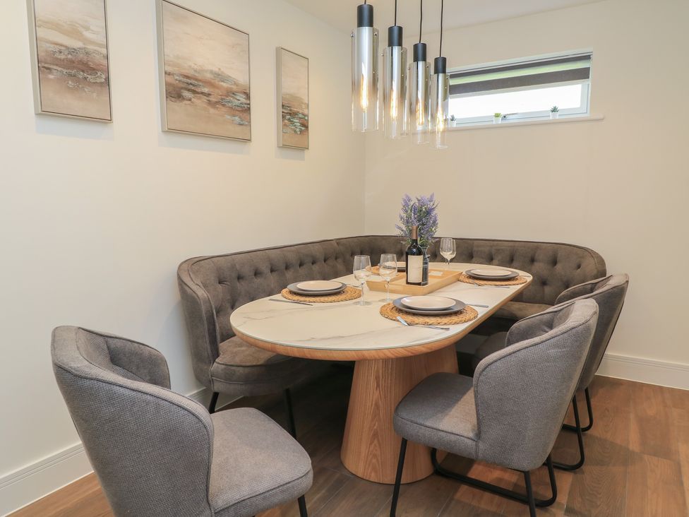 A dining room with a circular table and upholstered chairs at Pine Lodge Westonzoyland nr. Bridgwater