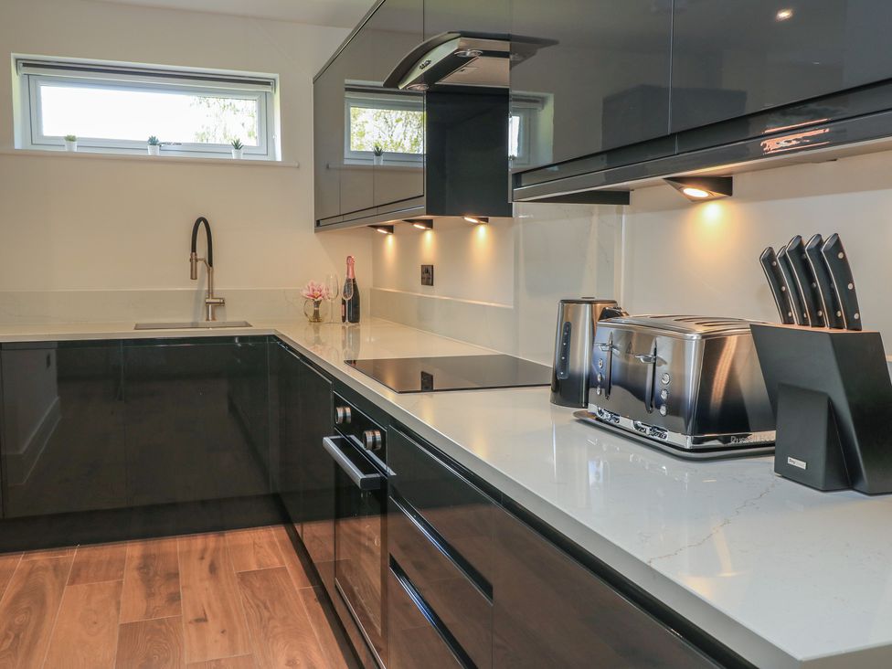 A kitchen with a sink, cooktop, toaster, and knife block at Pine Lodge in Westonzoyland nr. Bridgwater