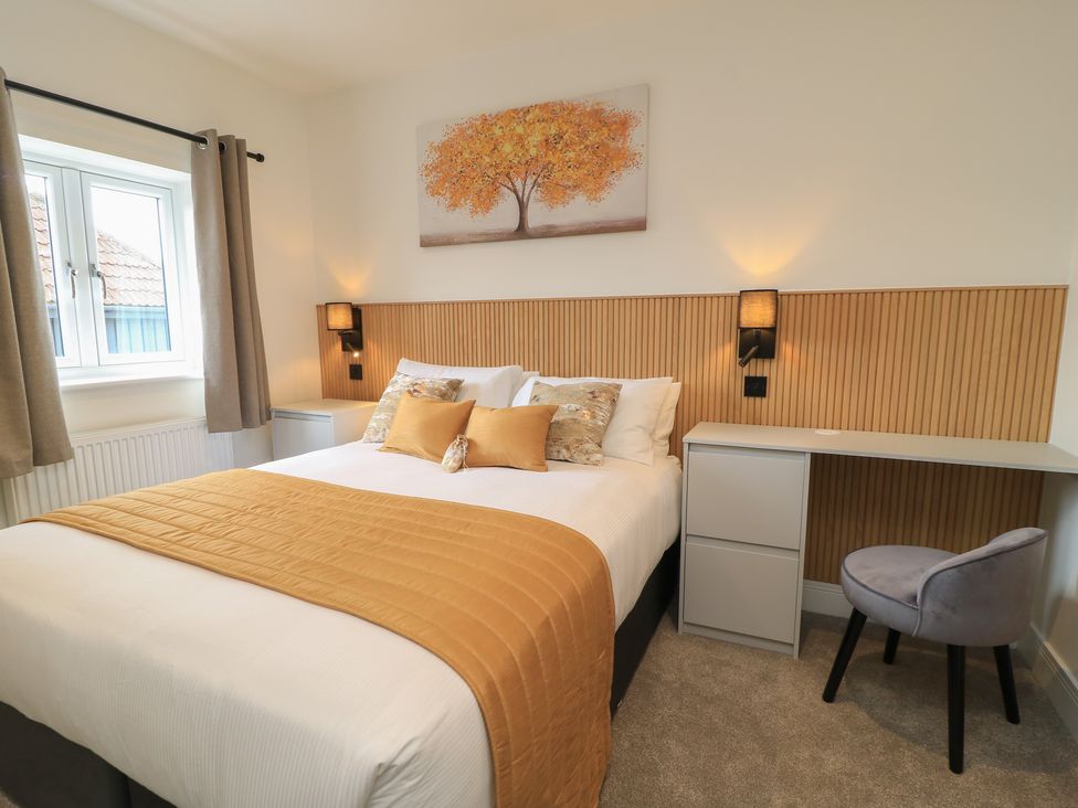 A bedroom with a bed and desk at Pine Lodge in Westonzoyland nr. Bridgwater