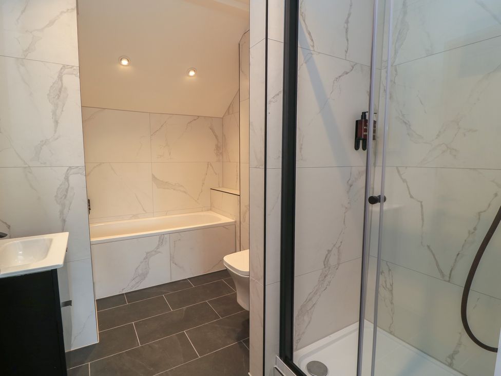 A bathroom with a bathtub, toilet, shower, and sink at Pine Lodge in Westonzoyland nr. Bridgwater