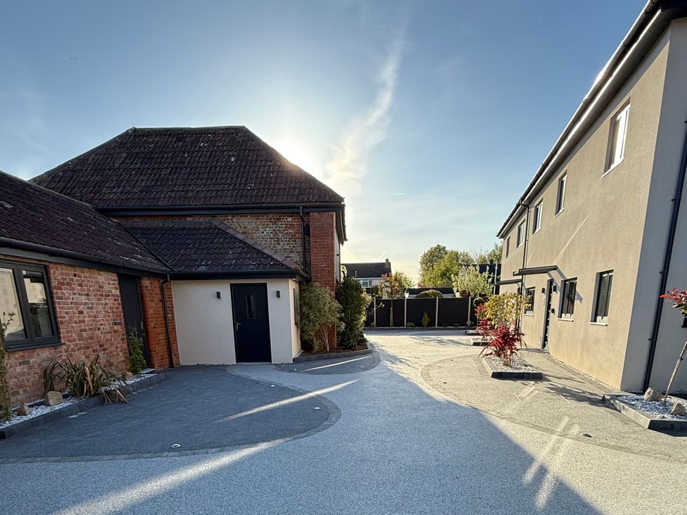 An outdoor area with houses and driveway at Pine Lodge in Bridgwater
