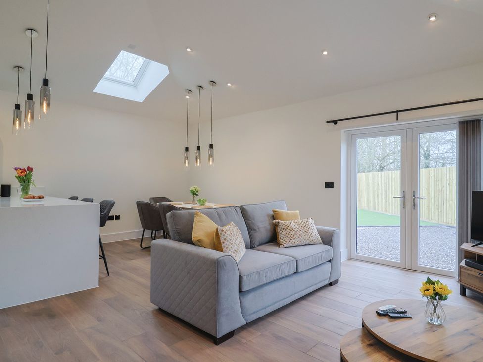 A living room with a sofa and dining area at Maple Lodge in Westonzoyland nr. Bridgwater