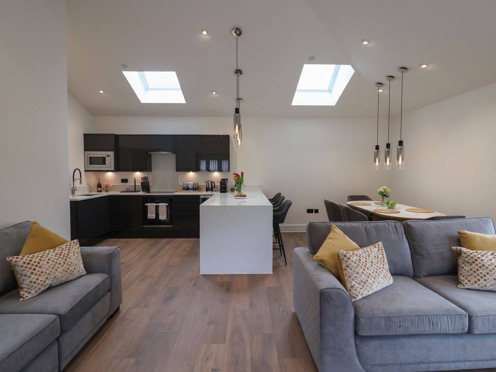 A living room with a kitchen area featuring a dining table at Maple Lodge Westonzoyland nr. Bridgwater