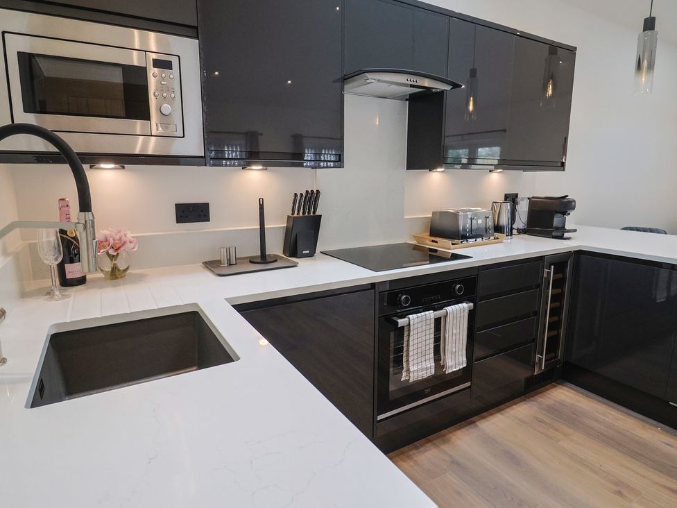 A kitchen with a microwave, oven, and sink at Maple Lodge Westonzoyland nr. Bridgwater