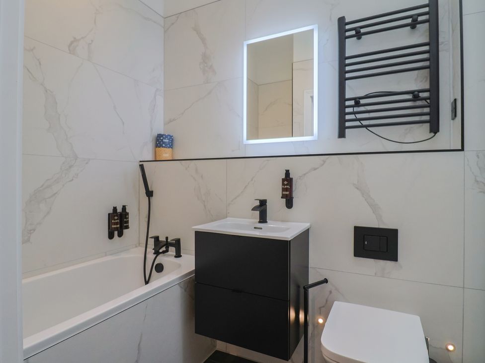 A bathroom with a bathtub and sink at Maple Lodge Westonzoyland nr. Bridgwater