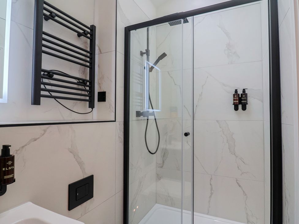 A shower with glass doors and towel rack at Maple Lodge in Westonzoyland nr. Bridgwater