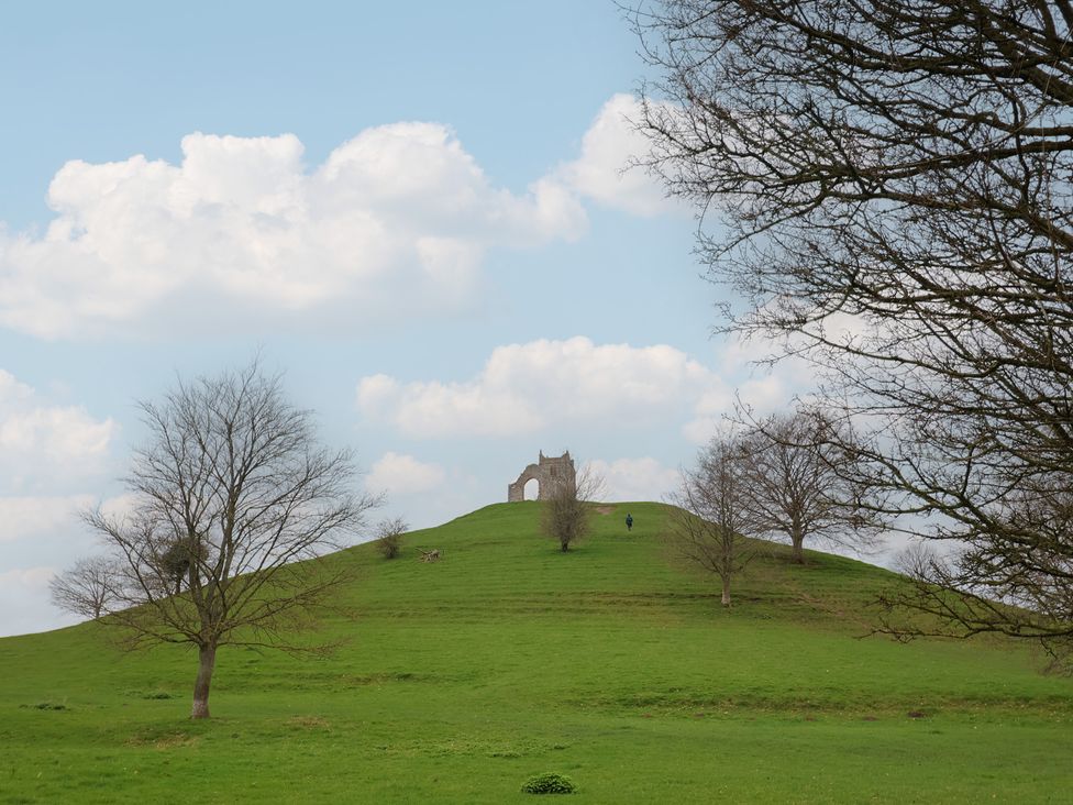 A hill with ruins and a person walking at Maple Lodge Westonzoyland nr. Bridgwater