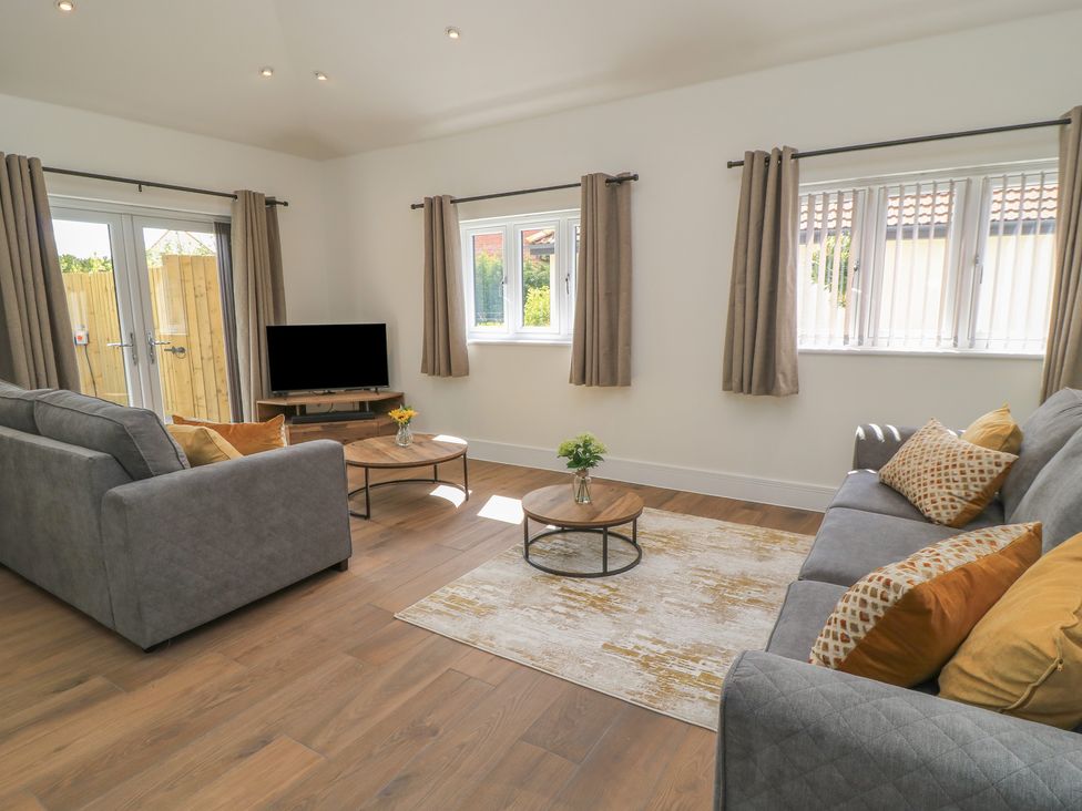 A living room with a television and sofa at Maple Lodge in Westonzoyland near Bridgwater