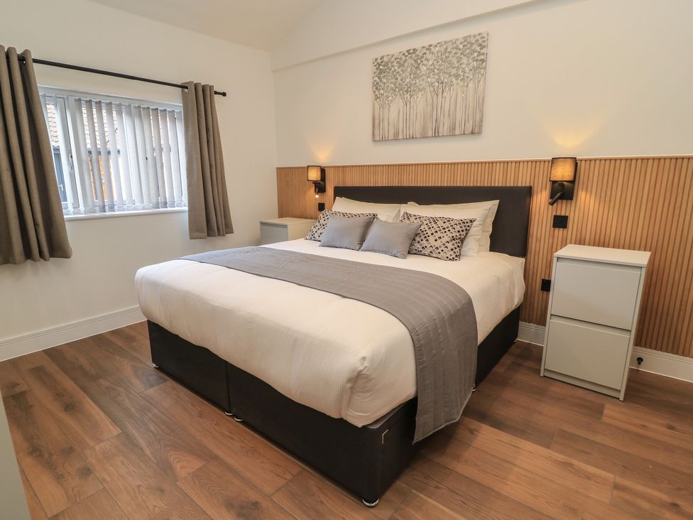 A bedroom with a bed and nightstand at Maple Lodge in Westonzoyland near Bridgwater