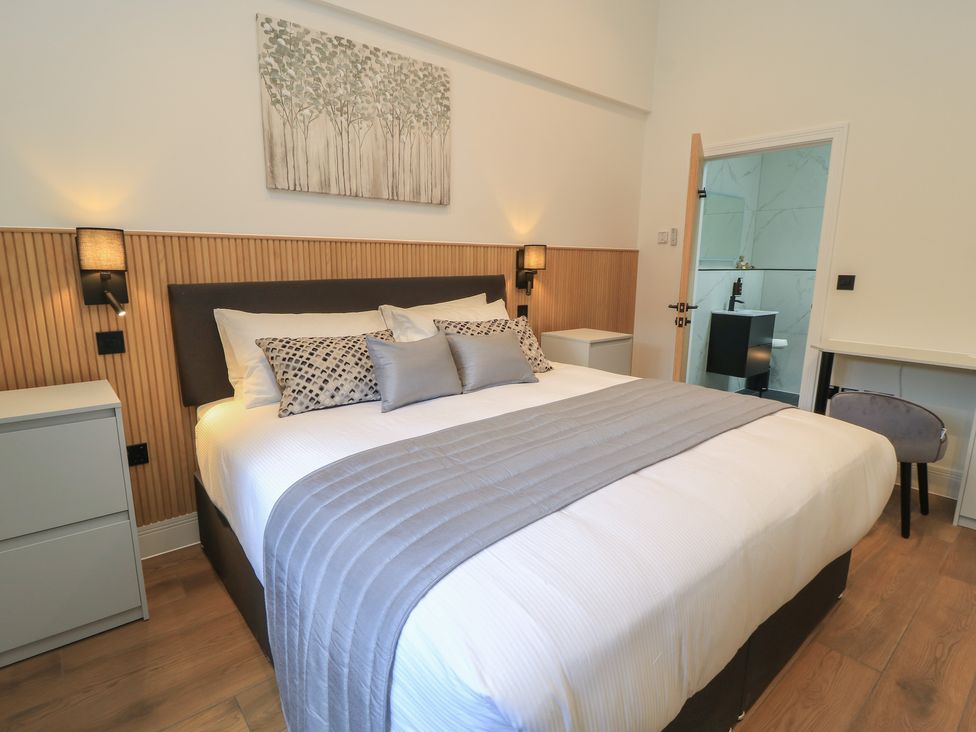 A bedroom with a bed and nightstand at Maple Lodge in Westonzoyland near Bridgwater