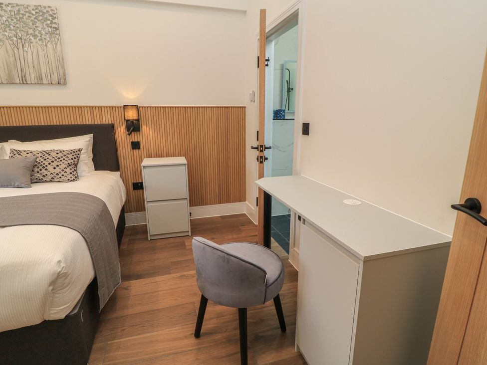 A bedroom with a bed, nightstand, desk, and chair at Maple Lodge Westonzoyland near Bridgwater