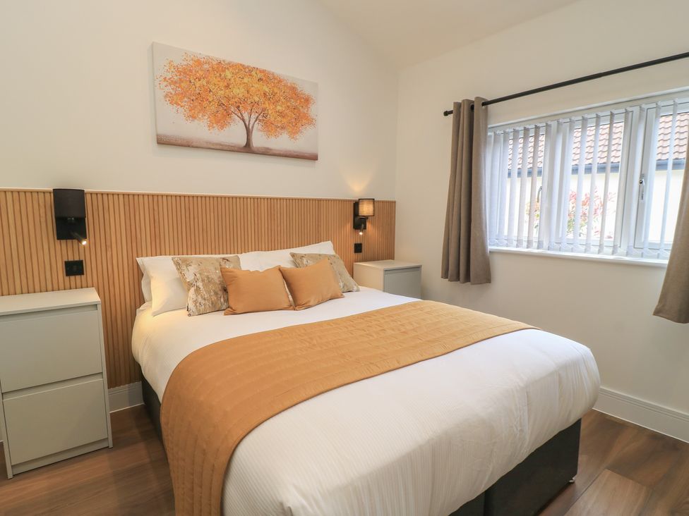 A bedroom with a bed and nightstands at Maple Lodge Westonzoyland near Bridgwater