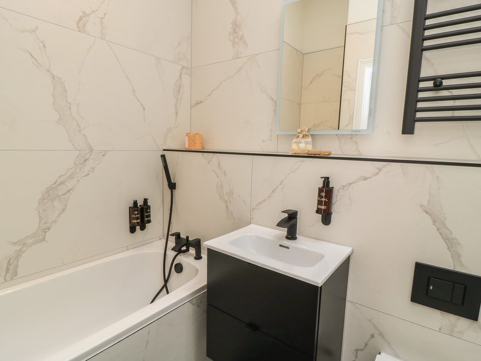 A bathroom with a bathtub and sink at Maple Lodge in Westonzoyland near Bridgwater