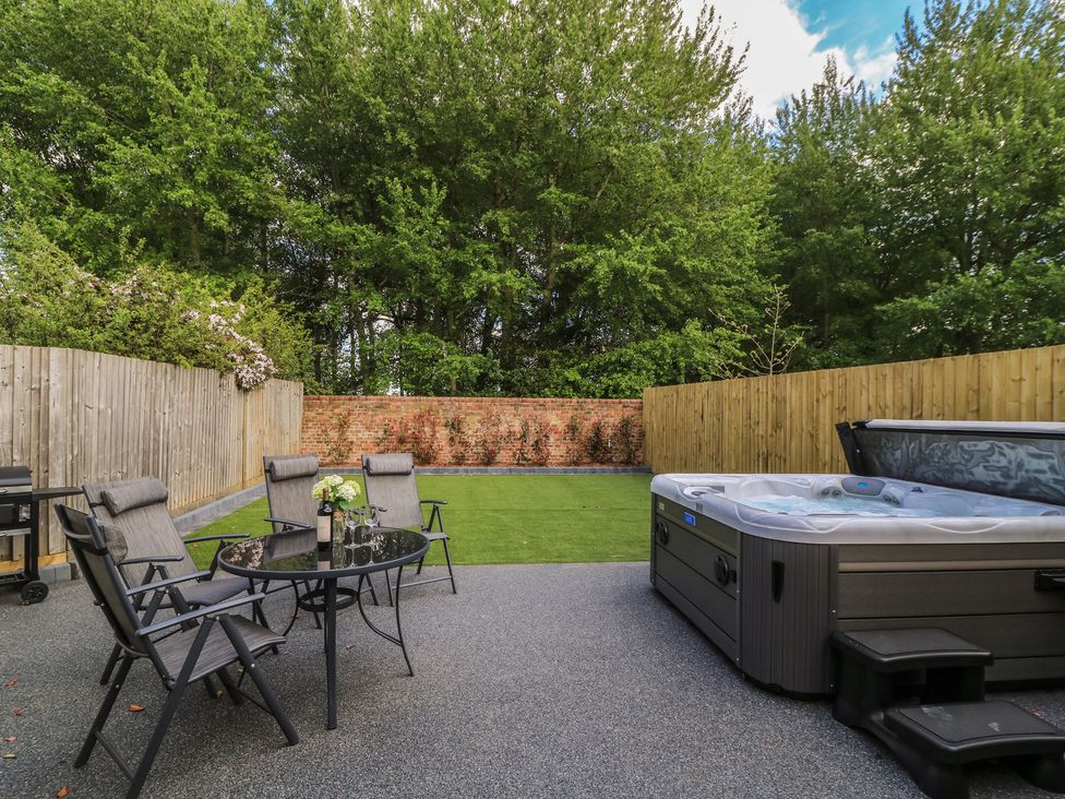 A garden with a hot tub and outdoor seating at Maple Lodge in Westonzoyland near Bridgwater