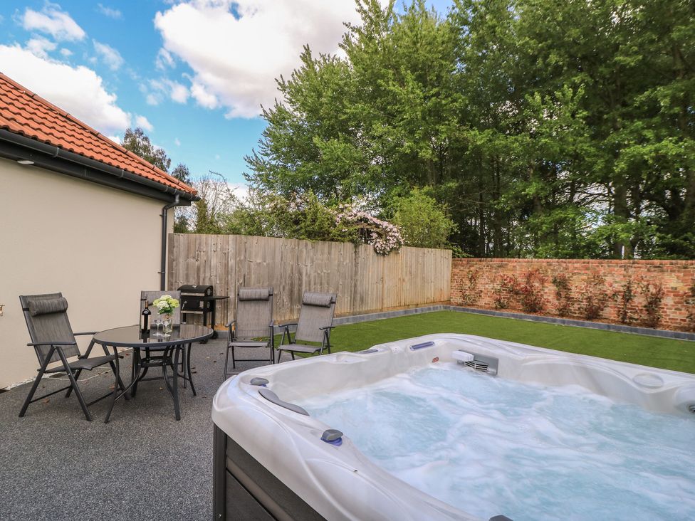 An outdoor area with a hot tub and seating at Maple Lodge Westonzoyland near Bridgwater