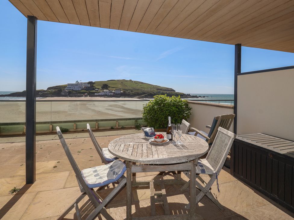 An outdoor terrace with a table and chairs at 6 Burgh Island in Bigbury-On-Sea