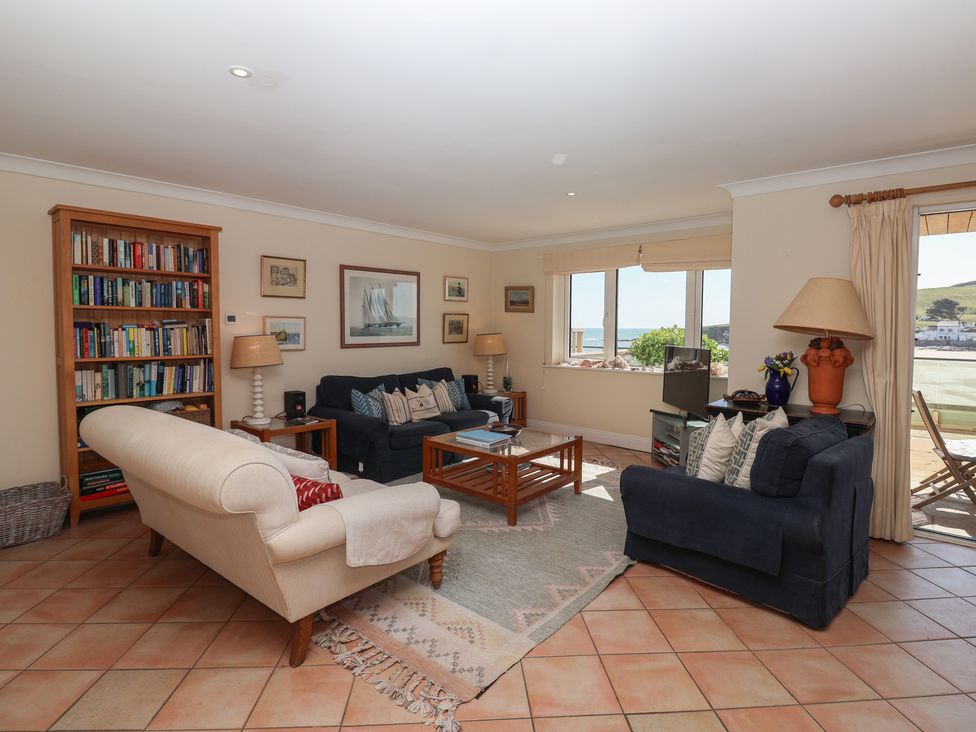 A living room with a bookshelf and sofas at 6 Burgh Island in Bigbury-On-Sea