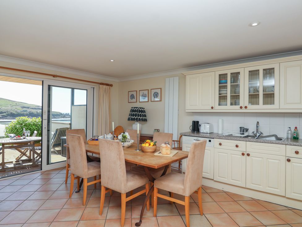 A kitchen with a dining area and view of the outdoors at 6 Burgh Island in Bigbury-On-Sea