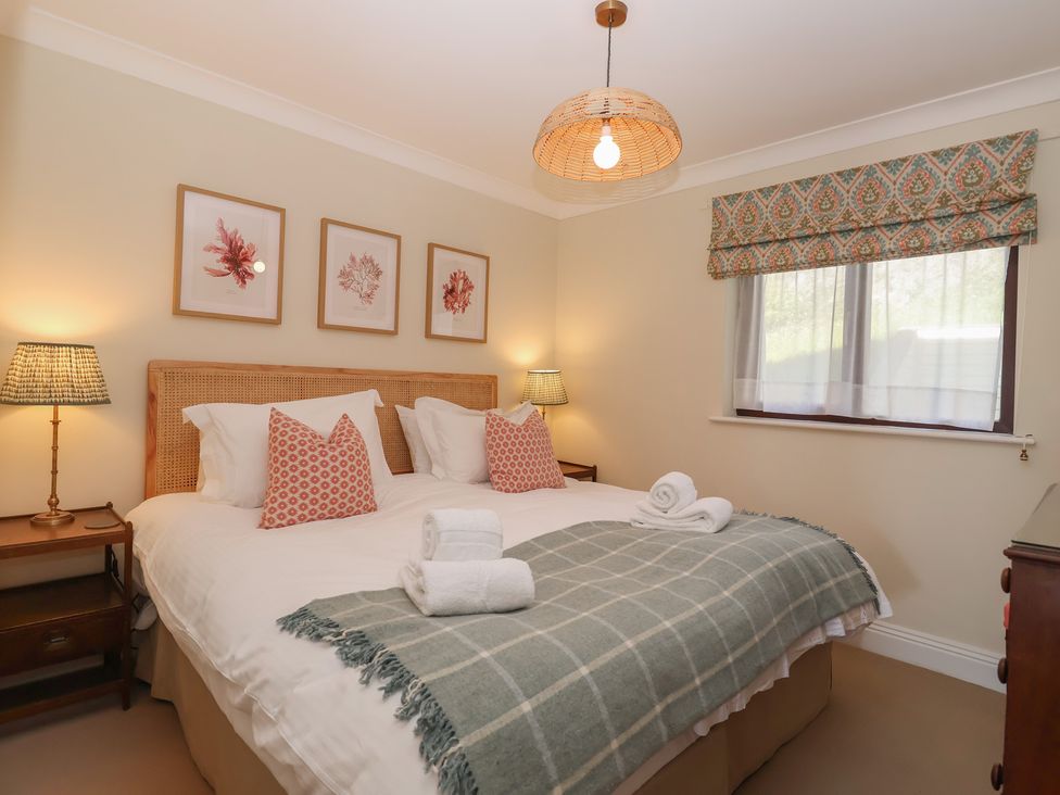 A bedroom with two beds and a bedside table at 6 Burgh Island in Bigbury-On-Sea