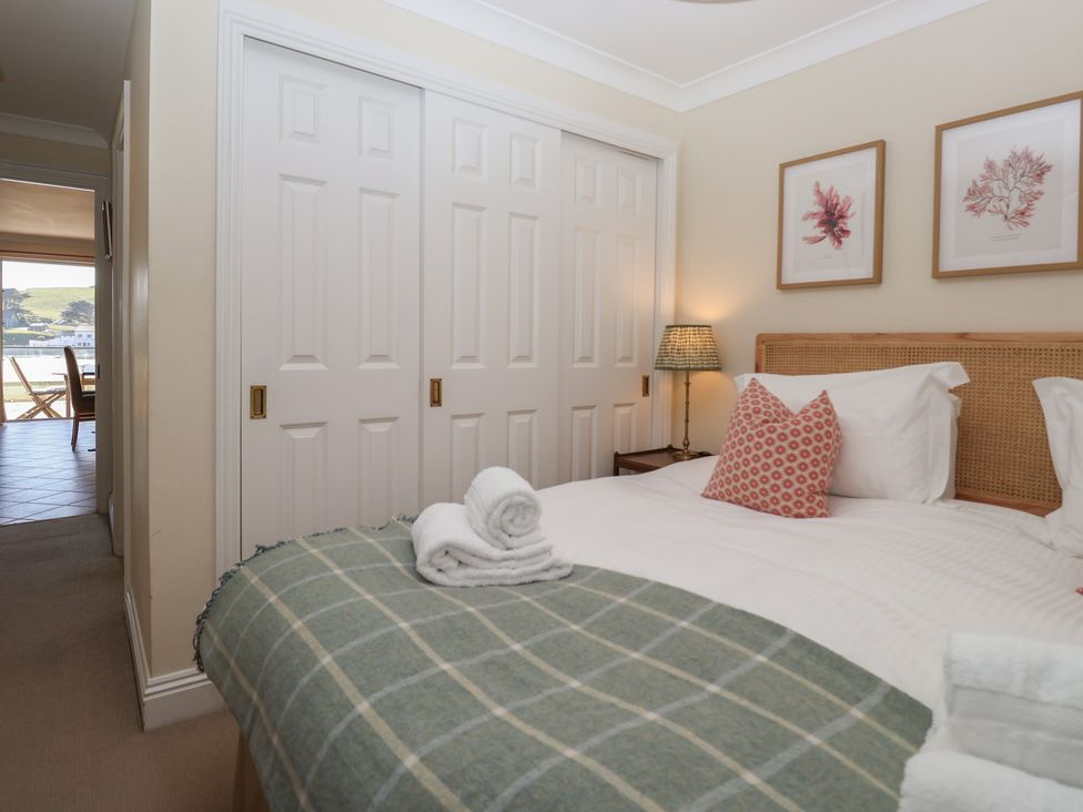 A bedroom with a bed and wardrobe at 6 Burgh Island in Bigbury-On-Sea