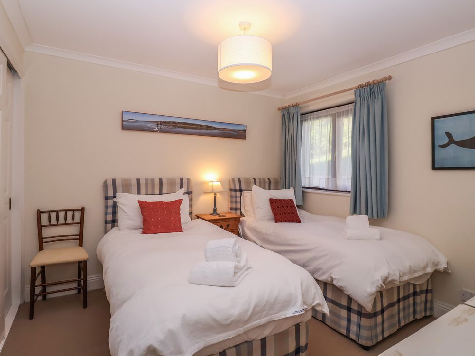A bedroom with two single beds and a chair at 6 Burgh Island Bigbury-On-Sea