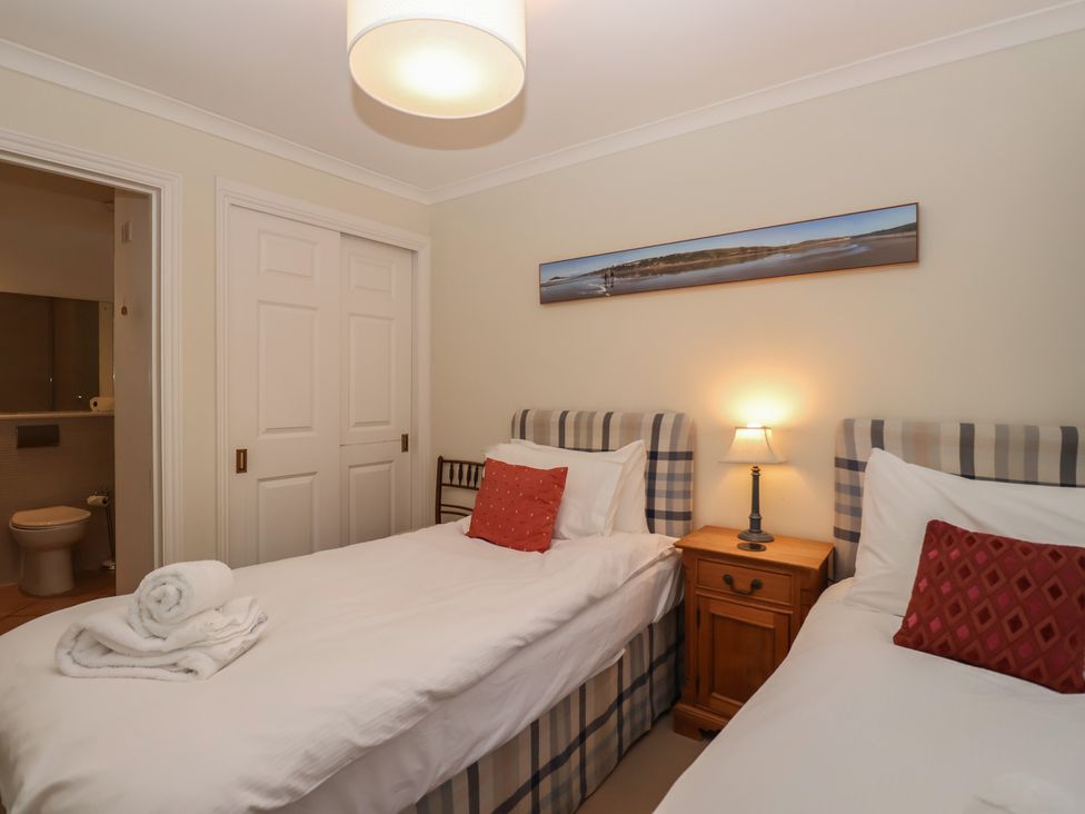 A bedroom with two beds and a nightstand at 6 Burgh Island Bigbury-On-Sea