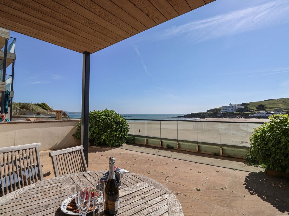 An outdoor patio with a table and champagne at 6 Burgh Island in Bigbury-On-Sea