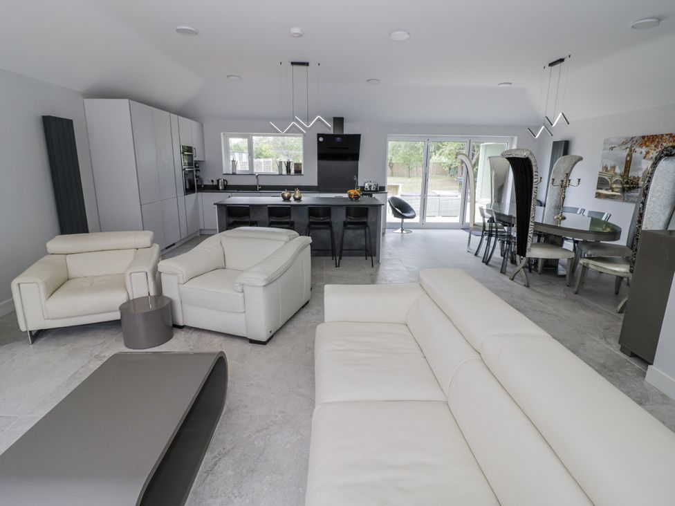 A living room with modern furniture and a kitchen area at Chillon South Littleton near Honeybourne