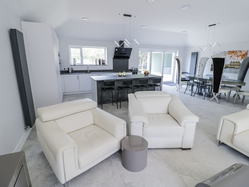 An open plan living area with a sofa and kitchen island at Chillon South Littleton near Honeybourne