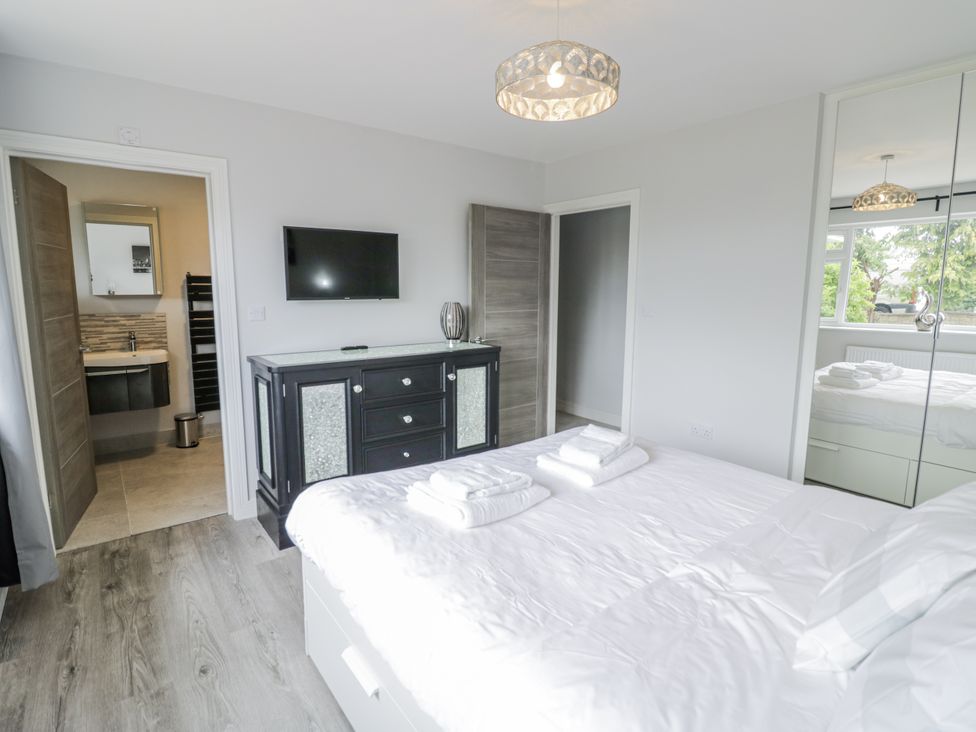 A bedroom with a bed and television at Chillon in South Littleton near Honeybourne
