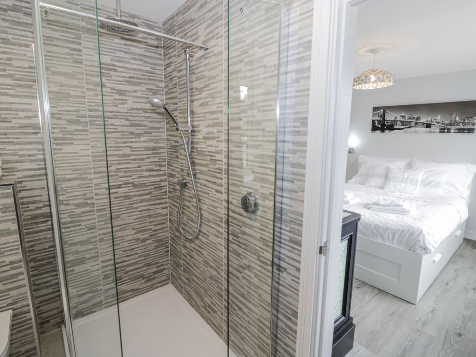 A bathroom with a shower and a bedroom at Chillon South Littleton near Honeybourne
