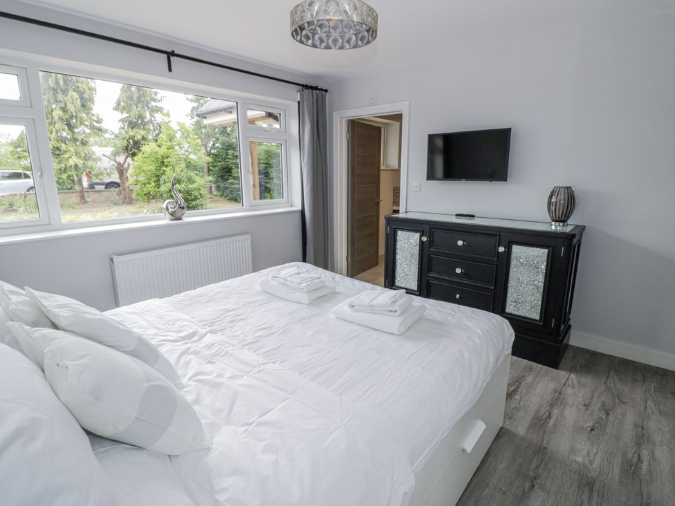 A bedroom with a bed and television at Chillon in South Littleton near Honeybourne