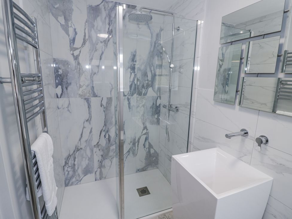 A bathroom with a glass shower and a white sink at Chillon South Littleton near Honeybourne
