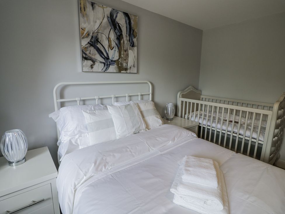 A bedroom with a bed and crib at Chillon South Littleton near Honeybourne