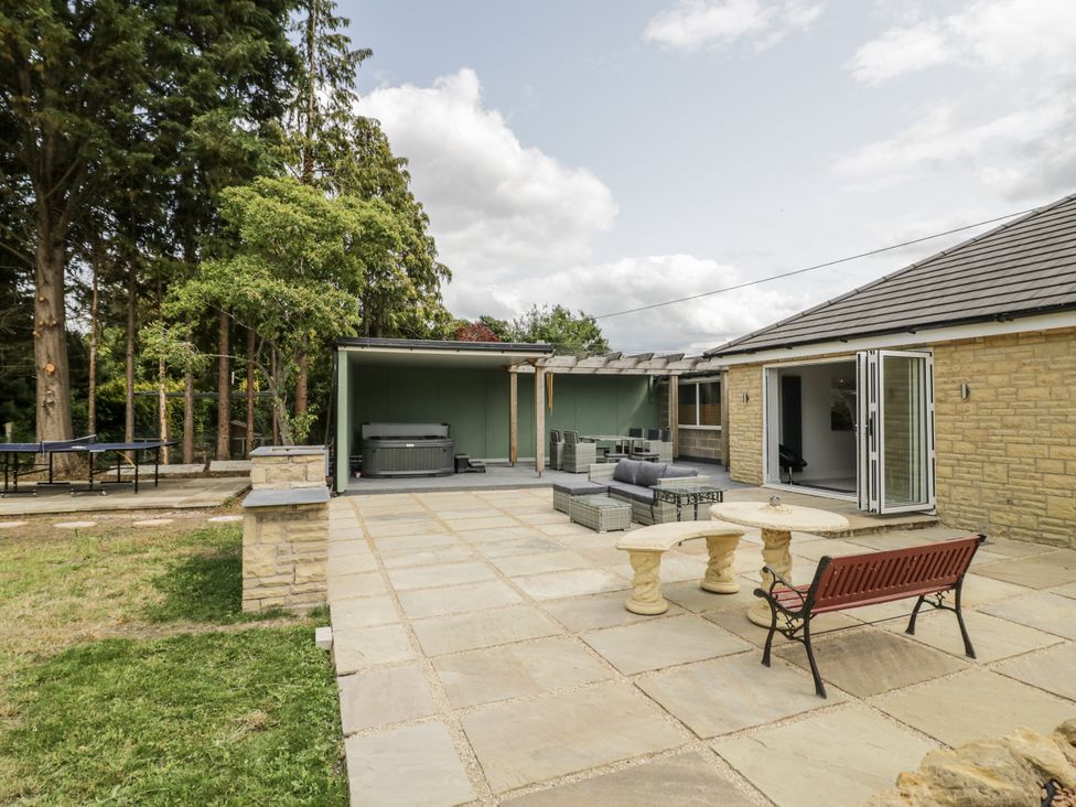 An outdoor space with a hot tub and seating area at Chillon in South Littleton near Honeybourne